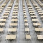 room with several tables and chairs lined up in several rows. 