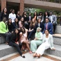 group of diverse students sitting outside on some steps. 