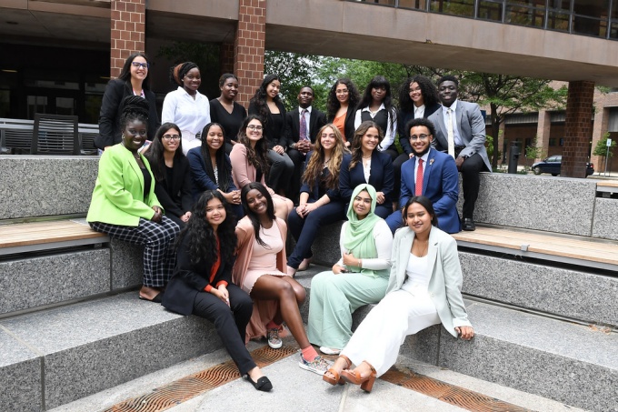 group of diverse students sitting outside on some steps. 