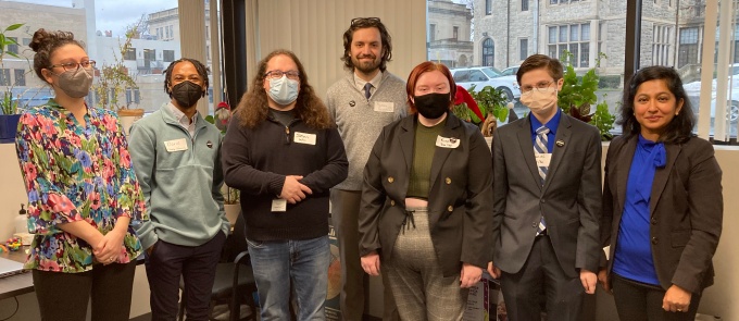 group of people, some wearing masks, smiling. 