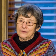 woman wearing a brightly colored sweater and glasses. 