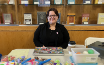 student sitting at a table selling colorful figit toys. 