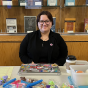 student sitting at a table selling colorful figit toys. 