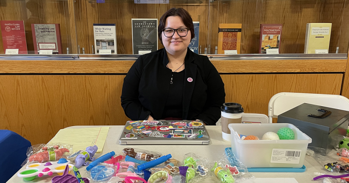 student sitting at a table selling colorful figit toys. 