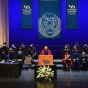 view of graduation state with woman speaking at the podium. 