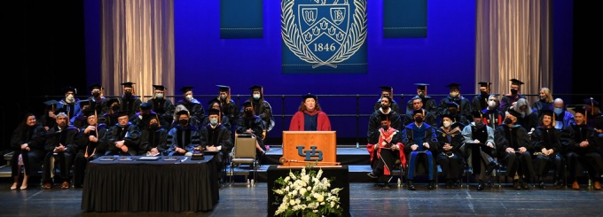 view of graduation state with woman speaking at the podium. 