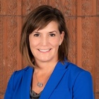 woman wearing blue jacket, smiling. 