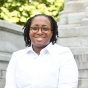 woman smiling, sitting outside of a courthouse. 