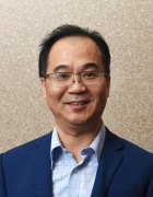 man wearing glasses, smiling. 