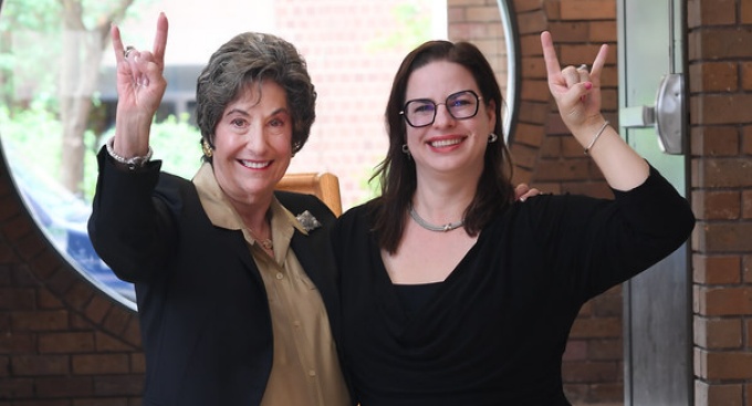 two women making UB Horns gestures. 