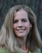 woman wearing green top, smiling. 