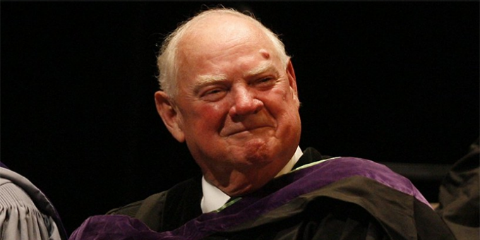 Joyce, smiling, wearing commencement regalia. 