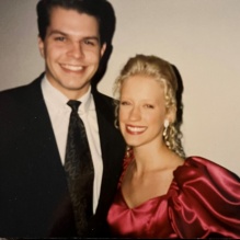 an older photo of man and woman, dressed formally, with decorative balloons. 