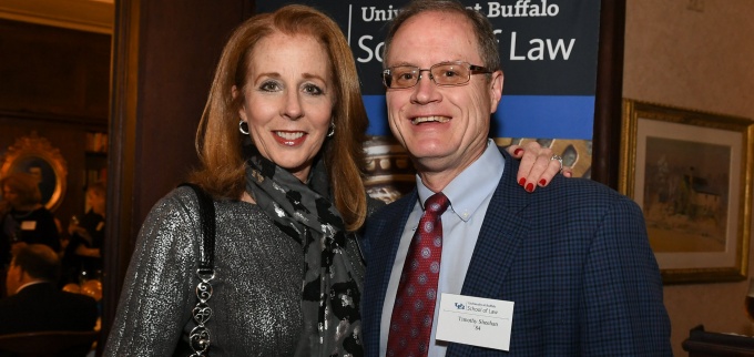 man and woman, smiling, attending a law school event. 