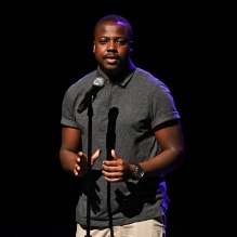 man standing on a stage with a microphone. 