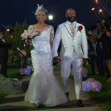 Zoom image: bride and groom walking down the isle