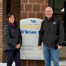 man and woman standing in front of a sign for O'Brian Hall. 