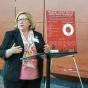 woman standing at a podium, talking. 