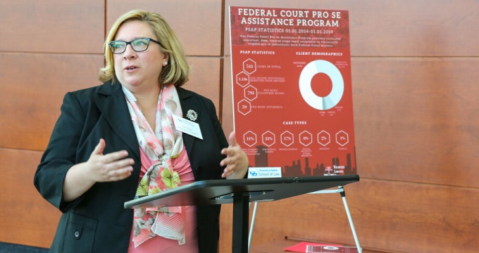 woman standing at a podium, talking. 