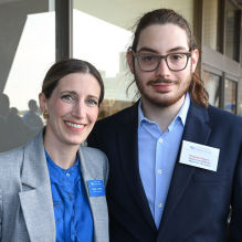 woman and man standing together, smiling. 