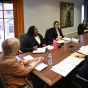 students sitting at a group of tables, facing each other, in a deep discussion. 