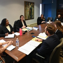 group of people sitting at a large conference table, in a deep discussion. 