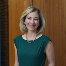 woman wearing green dress, smiling. 