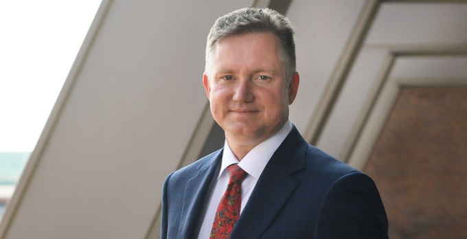 man in suit standing on a patio. 