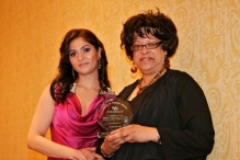 young womand giving an award to another woman. 