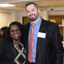 Smiling woman and man attending a social event. 