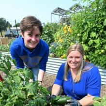 Women, smiling, working in a garden. 