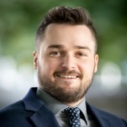 Man wearing business suit standing outside. 