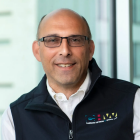 Man wearing glasses, black vest with text that says Channon Heyman & Weiss, LLP. 