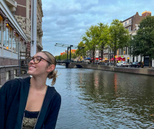 A young woman standing next to a channel in the Netherlands. 