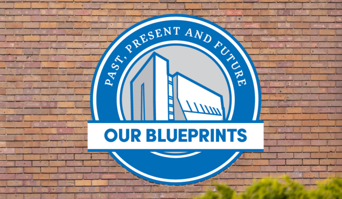 A circular blue and white logo displayed on a brick wall. The logo features an illustration of a modern building and includes the text 'Past, Present and Future' around the top and 'Our Blueprints' across the center on a banner. 