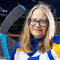 Nellie Drew in an arena holding hockey stick and wearing a jersey. 