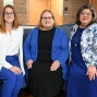 Three members of the law school community pose together in a campus common area. 