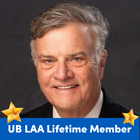 Headshot of a person against a dark background with a blue banner reading "UB LAA Lifetime Member" and gold star icons in the lower corners. 