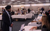 Law students talking to various public defenders office representatives. 