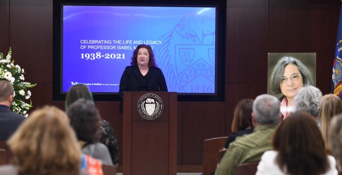 Dean Abramovsky standing at a podium, speaking to a room full of seated guests. 