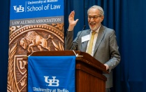 Zoom image: Judge Friedman at a podium addresses attendees during a University at Buffalo School of Law Alumni Association event.