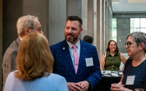 Zoom image: Attendees converse during a University at Buffalo School of Law alumni event inside a building.