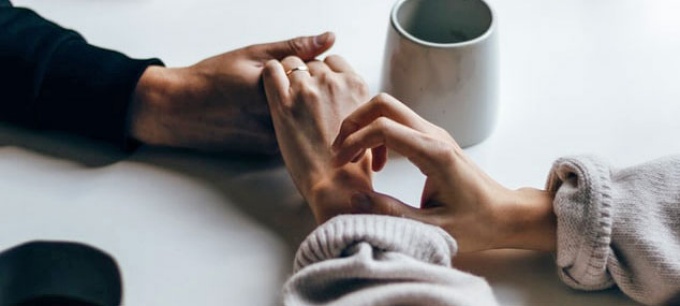 photo of hands holding across a table. 