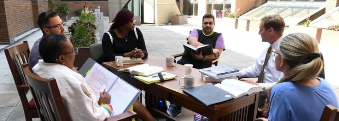 UB Law clinic students around an outdoor table studying and chatting. 