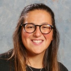 woman wearing glasses, smiling. 