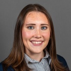 Gabby Cywinski wearing jacket, smiling. 