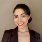 Professional portrait of Isabela (Isa) Budelmann wearing a black top. 